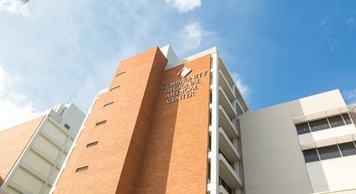 A close-up shot of Community Regional Medical Center with a bright blue sky behind it.